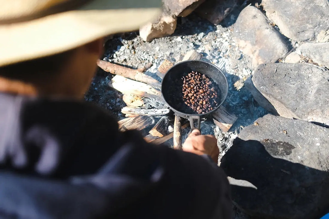 a man is cooking food over a campfire